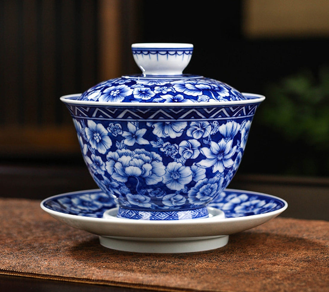 Blue-and-white Millefleurs gaiwan with its fitted lid and broad saucer on a wooden surface