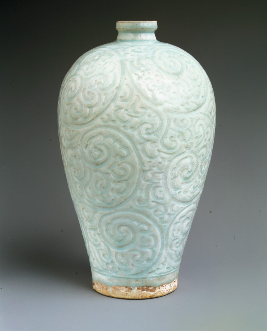 Qingbai bottle with a short narrow neck, rounded shoulders and curling foliage carved across a pale blue-green body