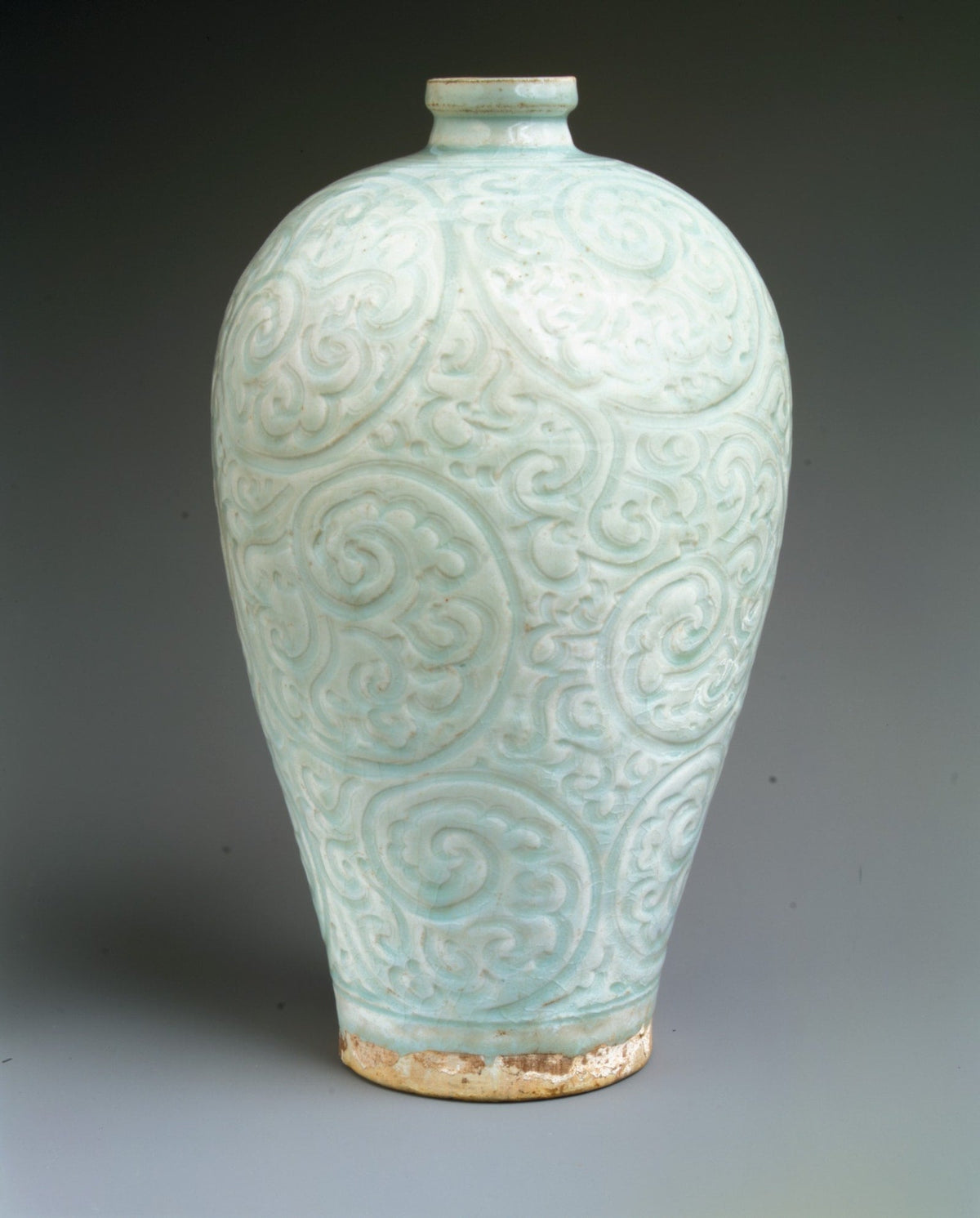 Qingbai bottle with a short narrow neck, rounded shoulders and curling foliage carved across a pale blue-green body