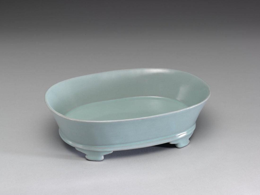 Oval Ru ware basin with a pale blue-green glaze and low shaped feet, seen without its display stand