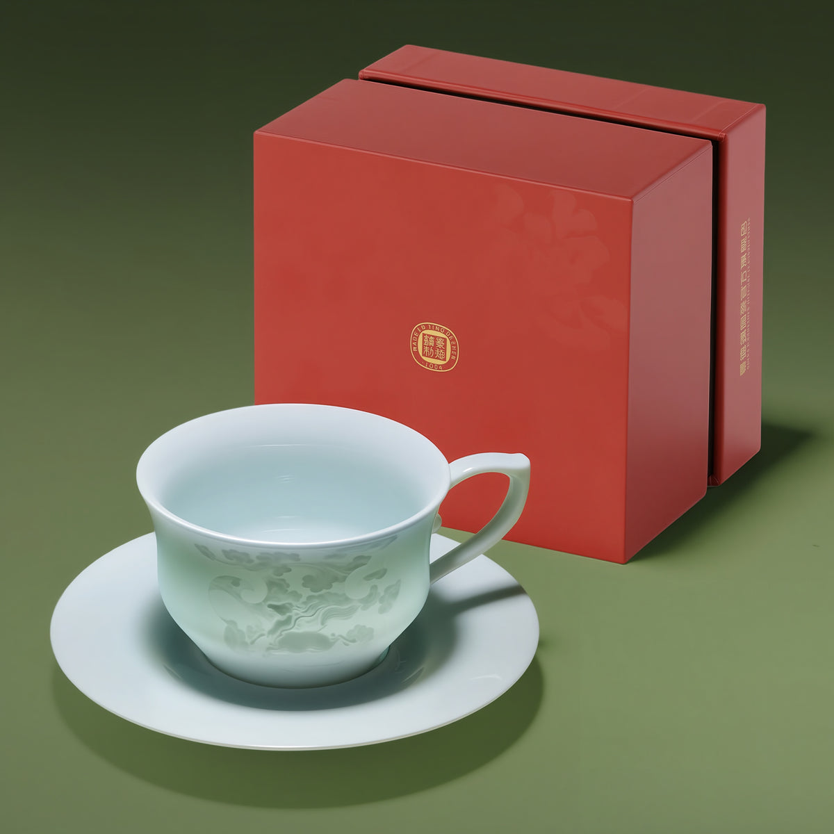 One Qingbai horse-pattern cup and matching saucer beside a small red gift box.