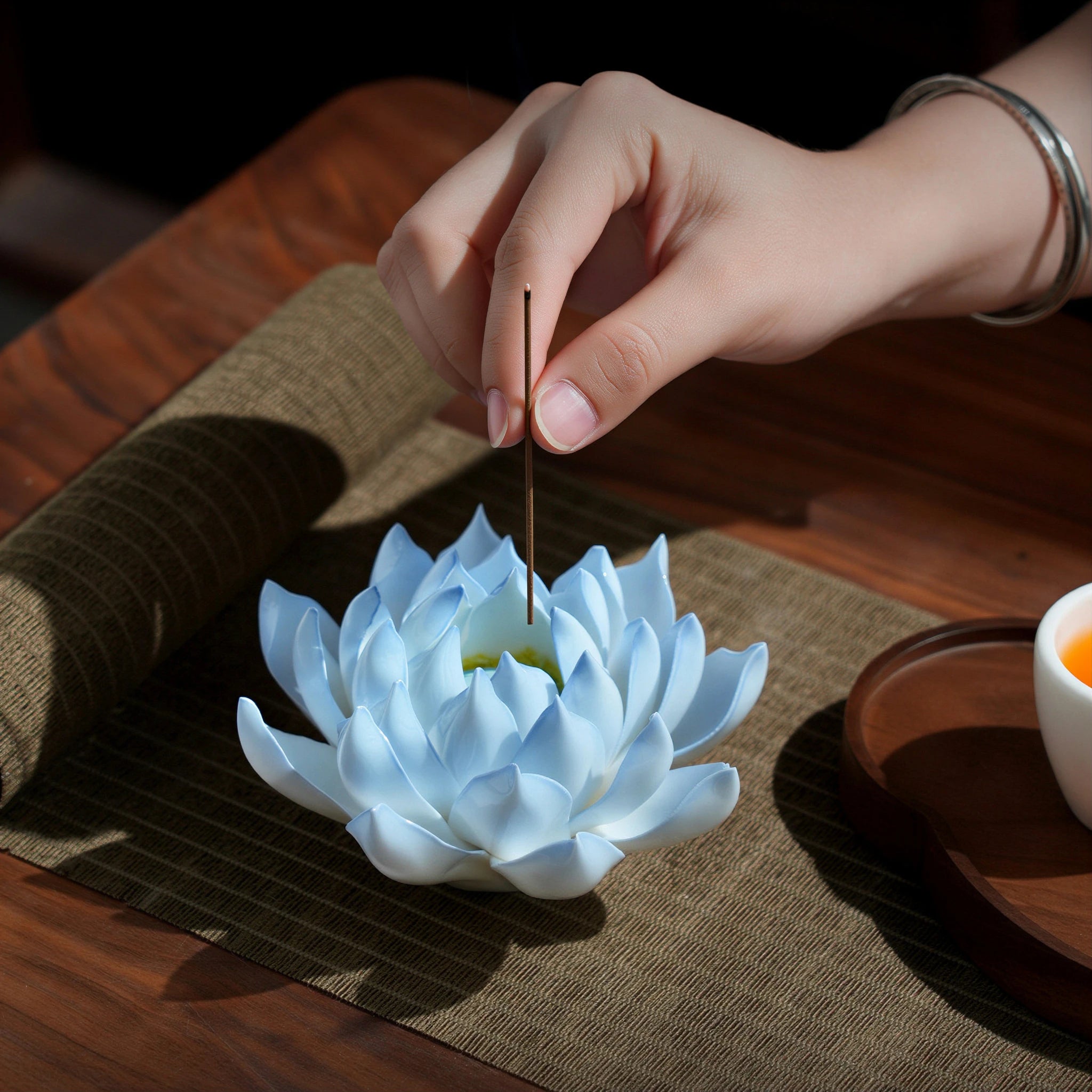 Incense smoke rising from an azure blue porcelain lotus
