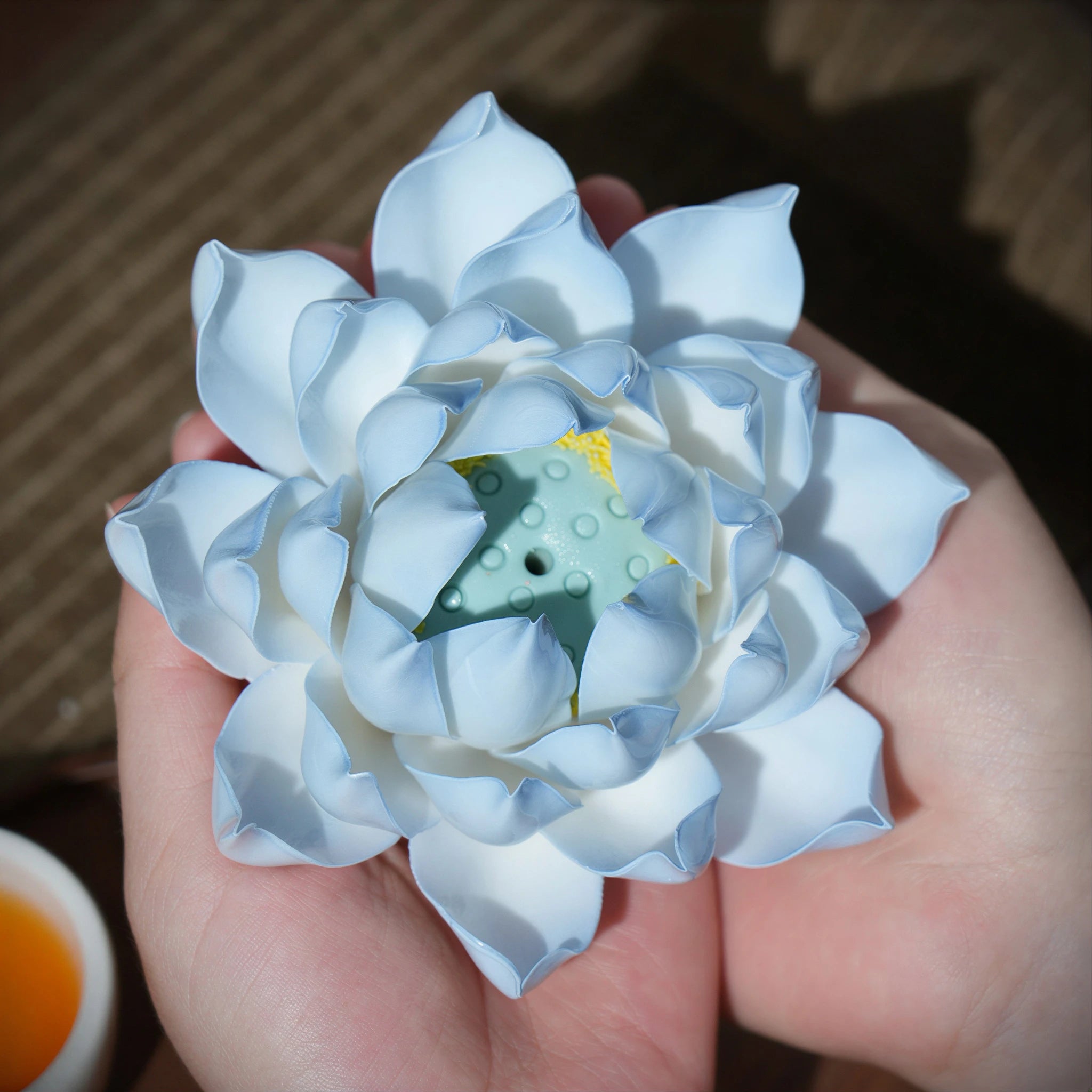 Azure blue porcelain lotus incense holder held in two hands