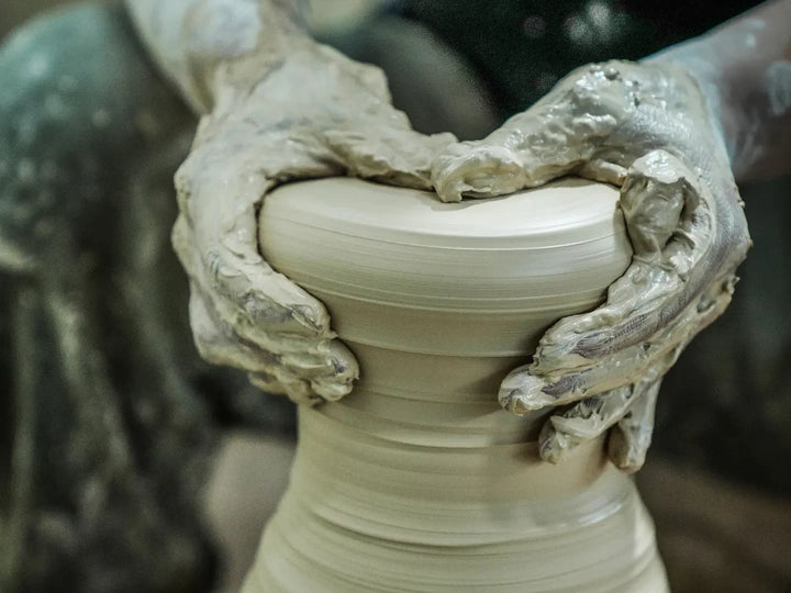 A potter shaping a vessel on the wheel