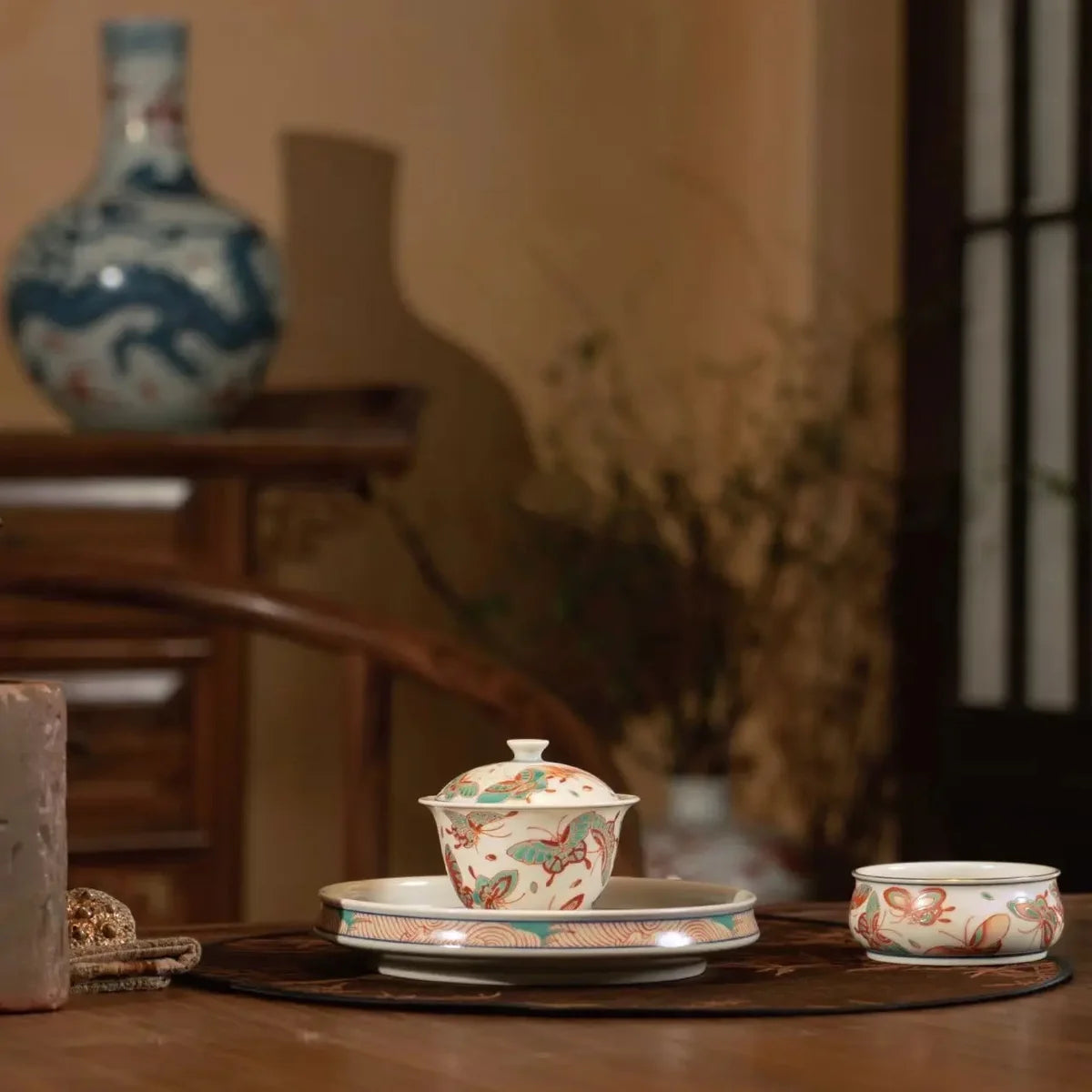 Painted porcelain gaiwan and tea cups on a tea table