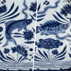 Hand-painted fish, lotus, and reed details in underglaze cobalt