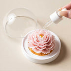 Fragrance oil being applied to the blush pink porcelain carnation