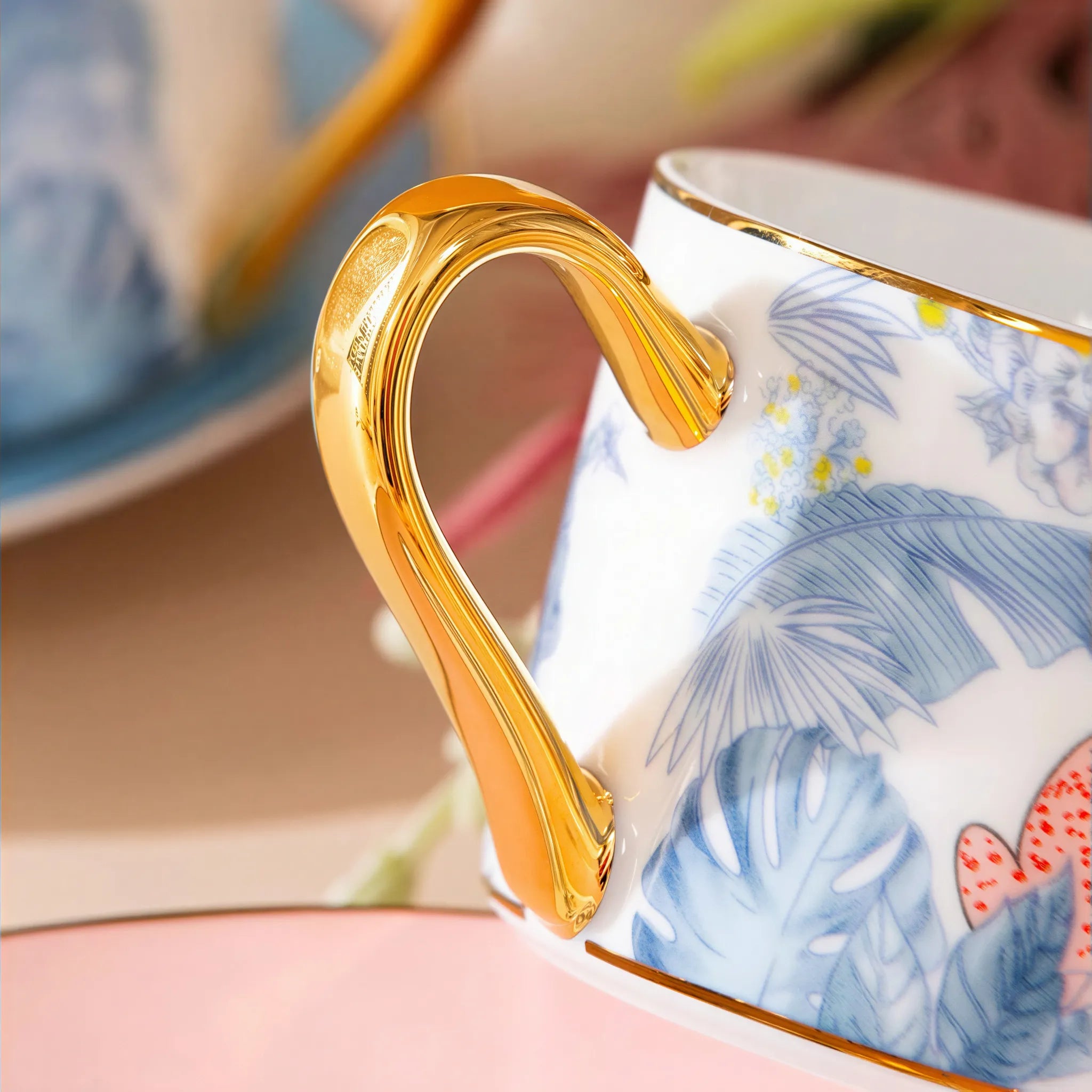 Gold-toned handle detail on the botanical leopard coffee cup