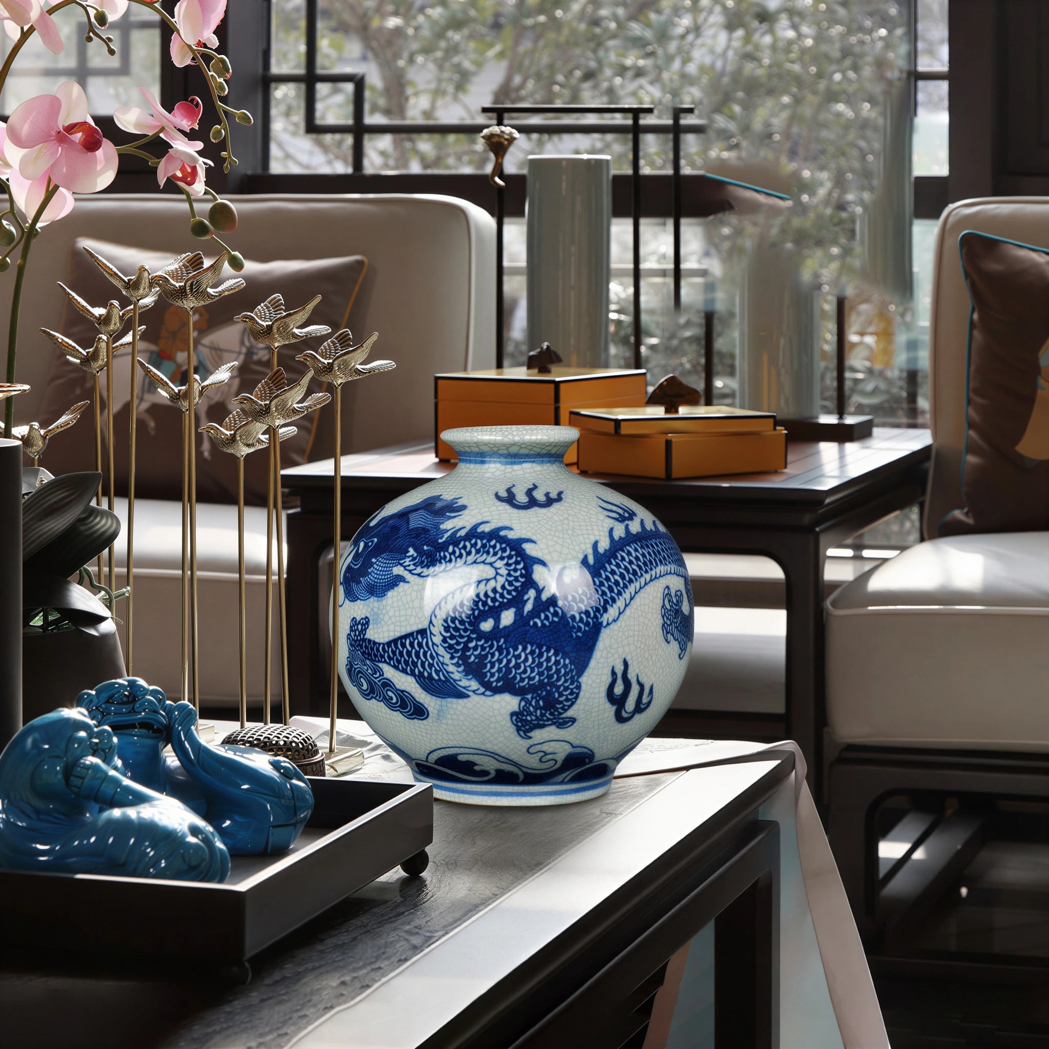 Wide-mouth cobalt dragon vase displayed on its wooden stand in a living room