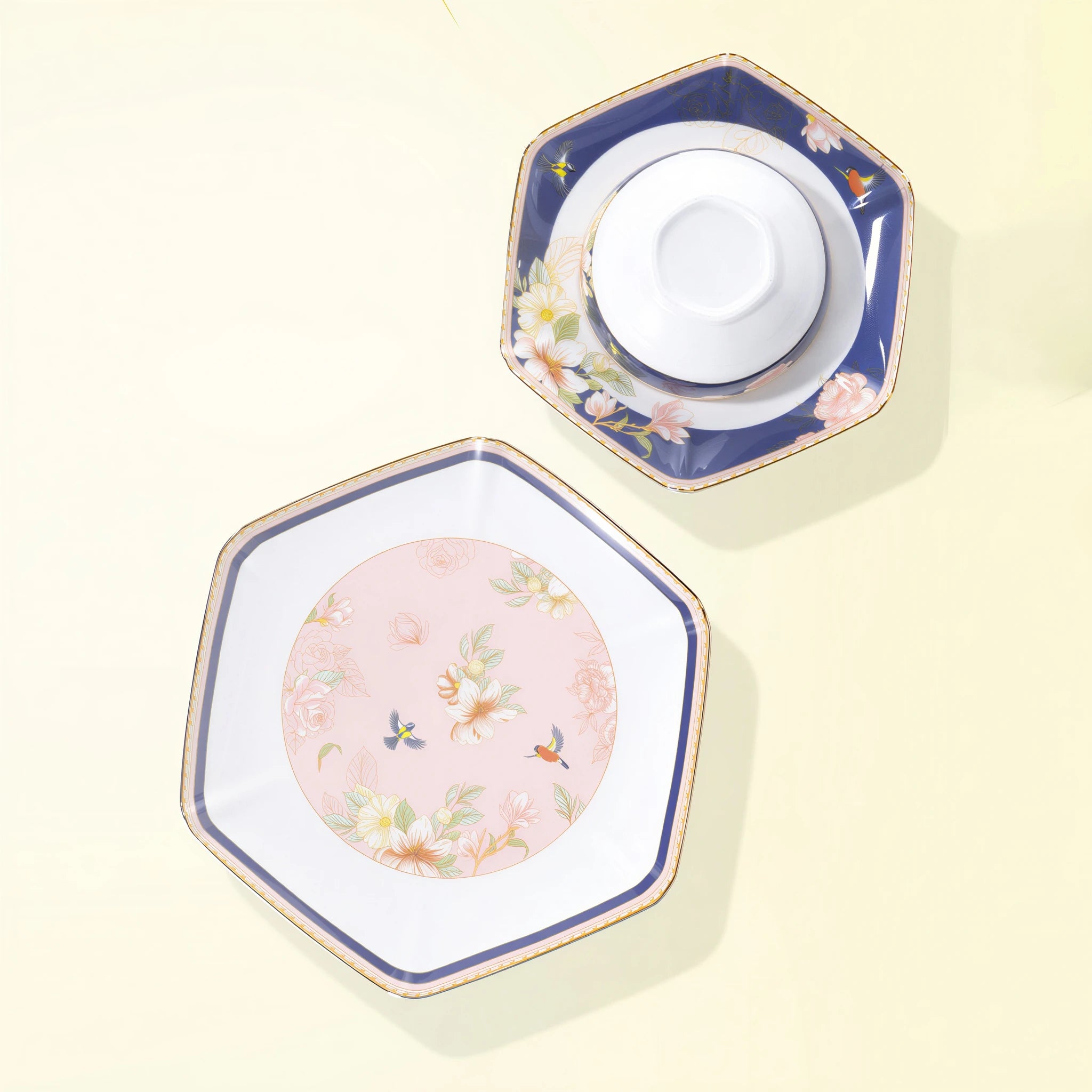 Blush-pink large plate beside a navy floral plate holding the inverted white porcelain rice bowl.