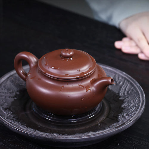 Dai Chenguang Fanggu teapot on a dark tea tray