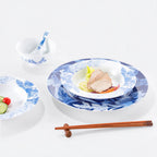 Deep Forest porcelain plates and bowl arranged with food on a white table.