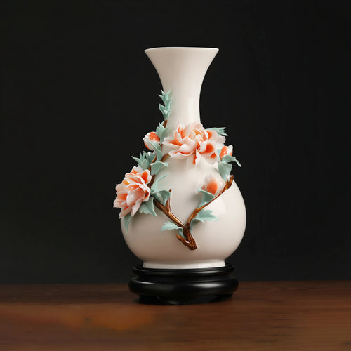 Front view of a coral peony relief porcelain vase on a black stand