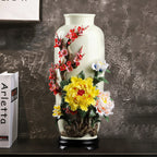 Tall floral relief porcelain vase displayed on a dark sideboard
