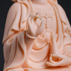 Detail of the raised hand and small vessel on the jade-red Guanyin figure