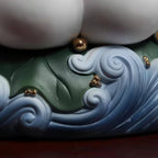 Lotus-and-wave base with restrained gold-toned details