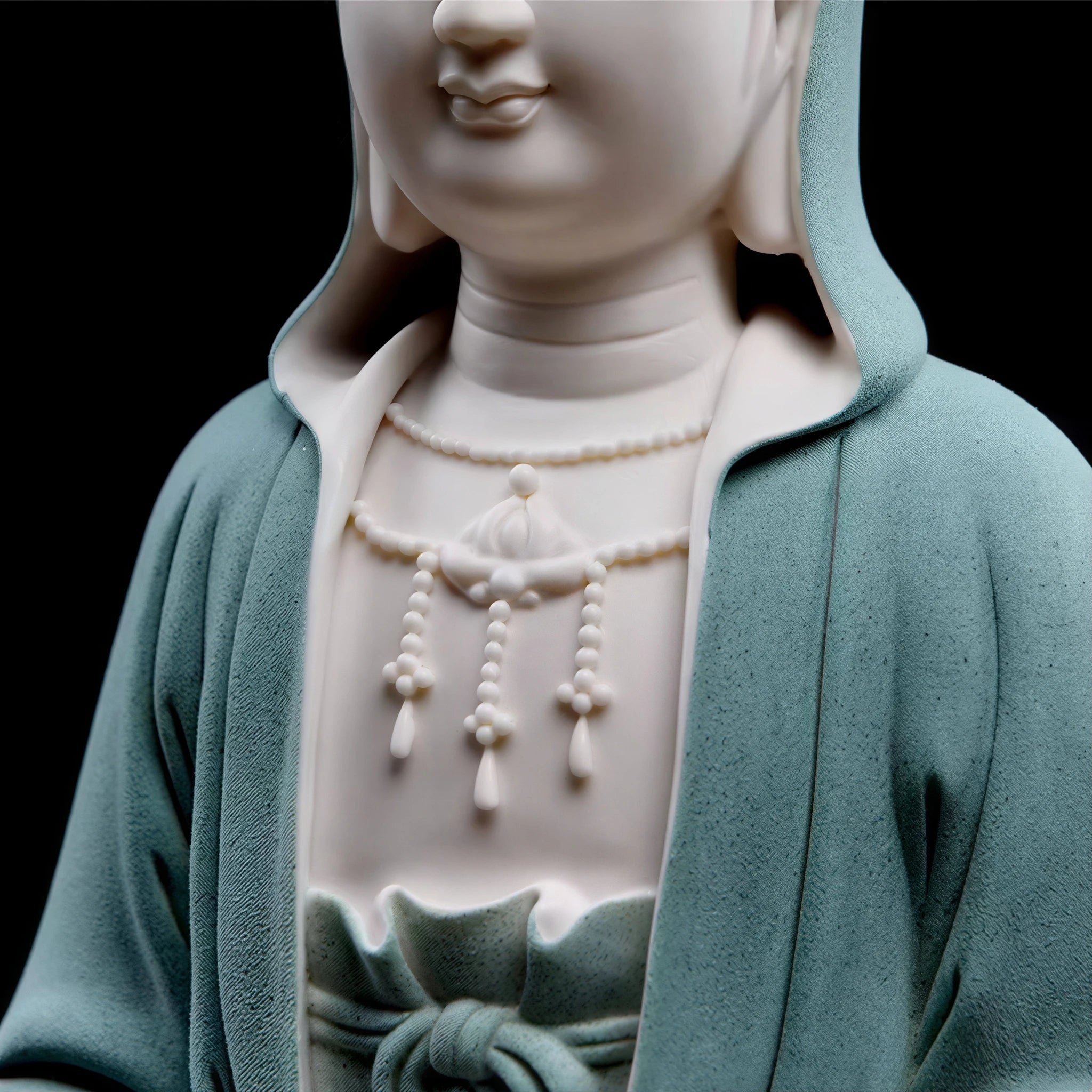 Detail of the hooded robe and chest jewelry on the Guanyin figure