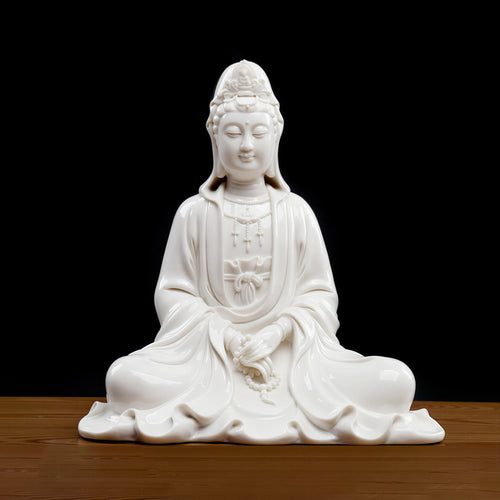 Front view of white Dehua porcelain hooded Guanyin in a broad seated pose