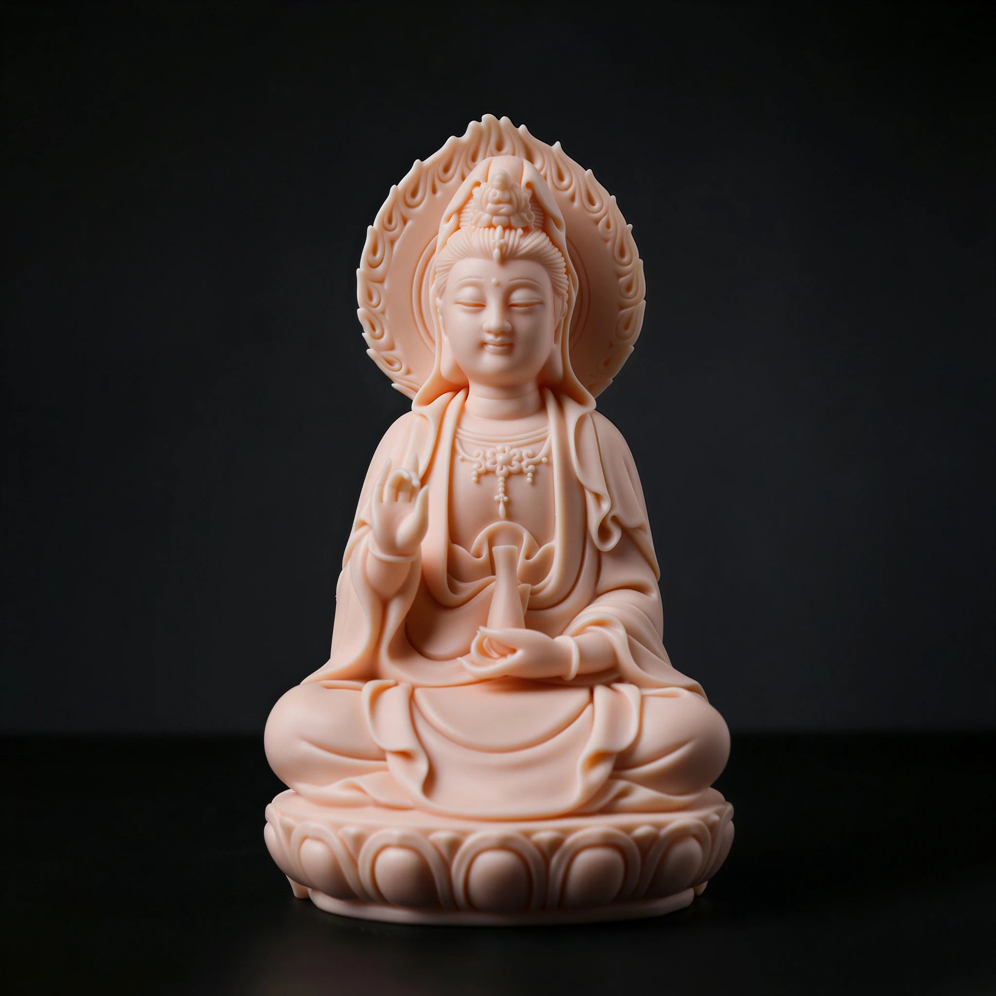 Front view of a jade-red Dehua porcelain Guanyin seated before a flame-shaped halo
