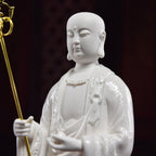 Close view of the Ksitigarbha face and gold-toned monk's staff