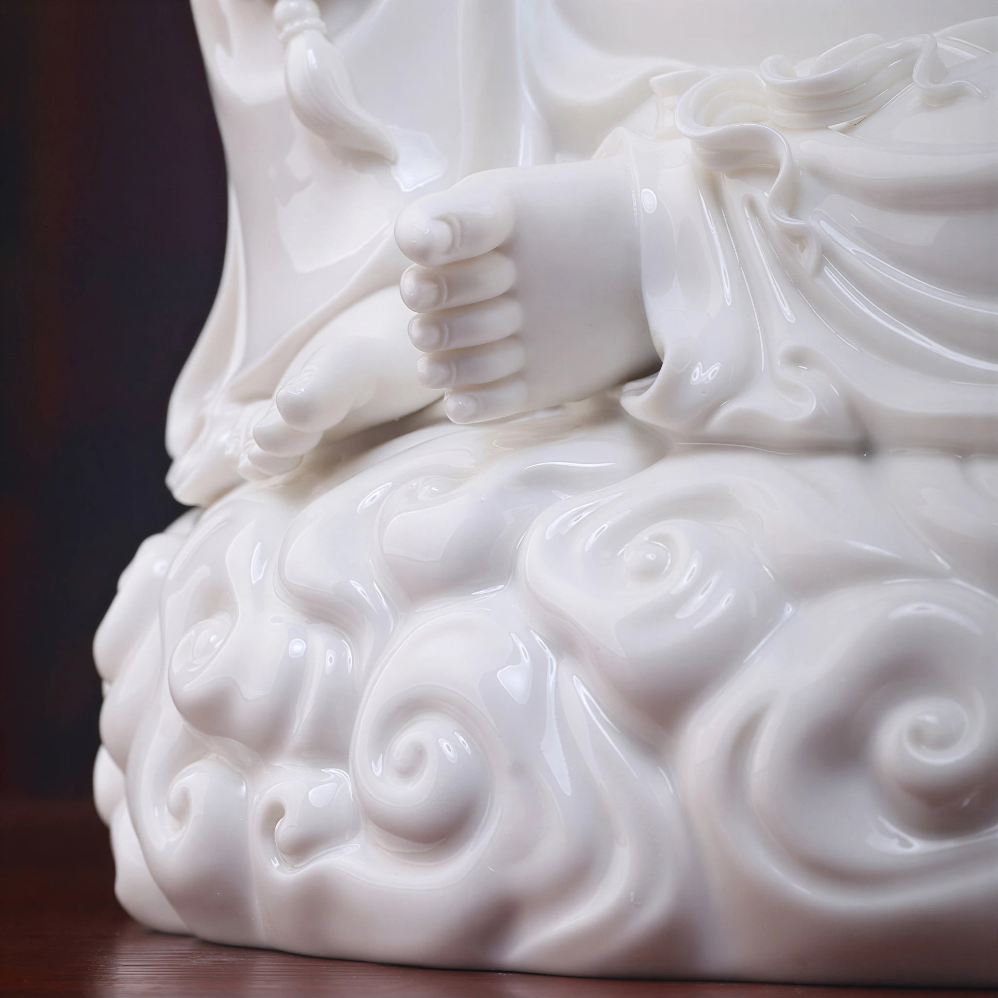Close view of the bare feet, robe folds, and sculpted cloud scrolls