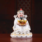 Angled view of a Dehua Caishen sculpture with gold-toned details