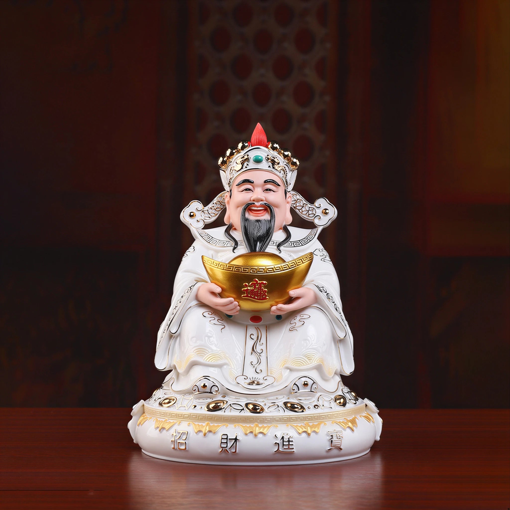 Front view of a painted Dehua porcelain Caishen holding a gold-colored ingot