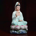 Pale blue Guanyin above a polychrome lotus-and-wave base