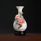 Front view of a pink peony relief porcelain vase on a black stand