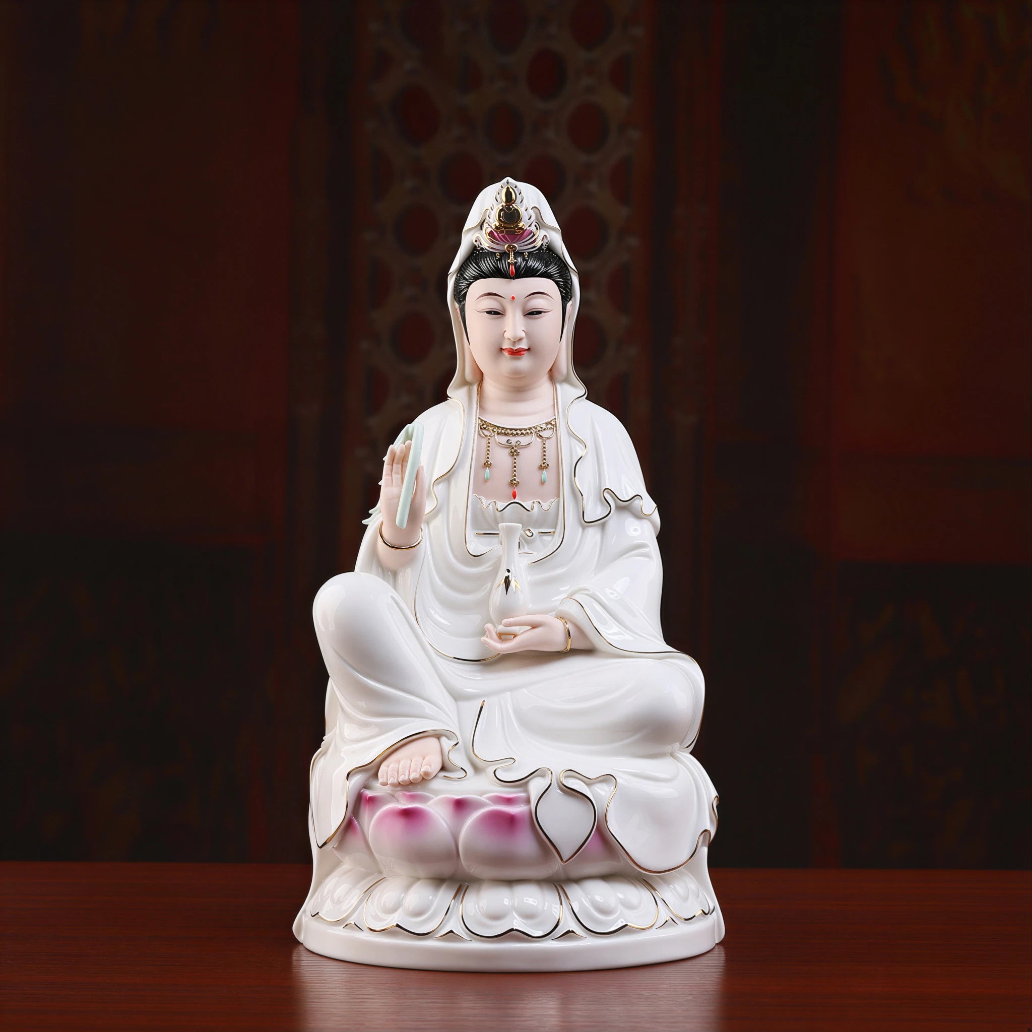Front view of a polychrome Dehua porcelain Guanyin seated on a pink lotus