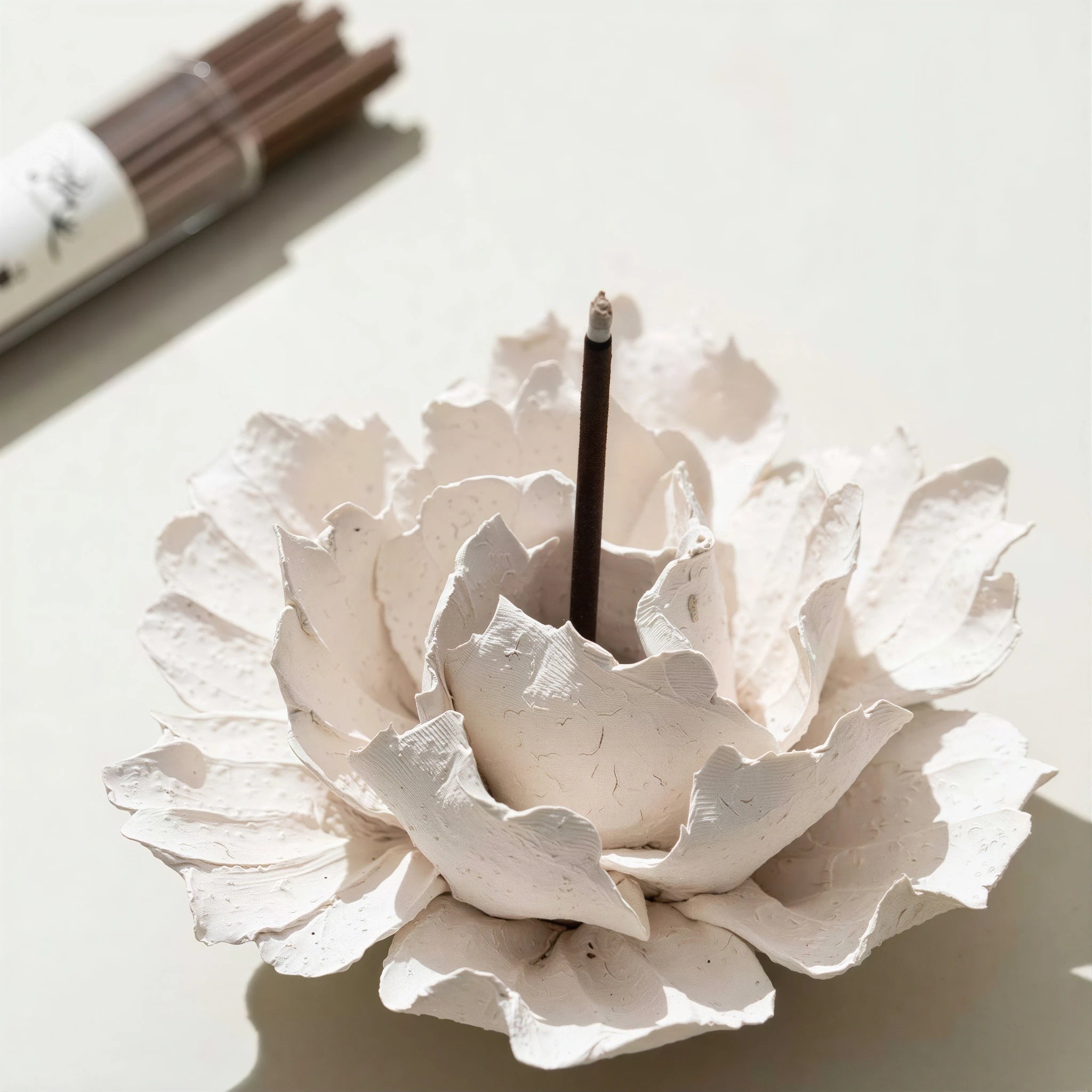 Incense being lit in the center of the textured ceramic blossom