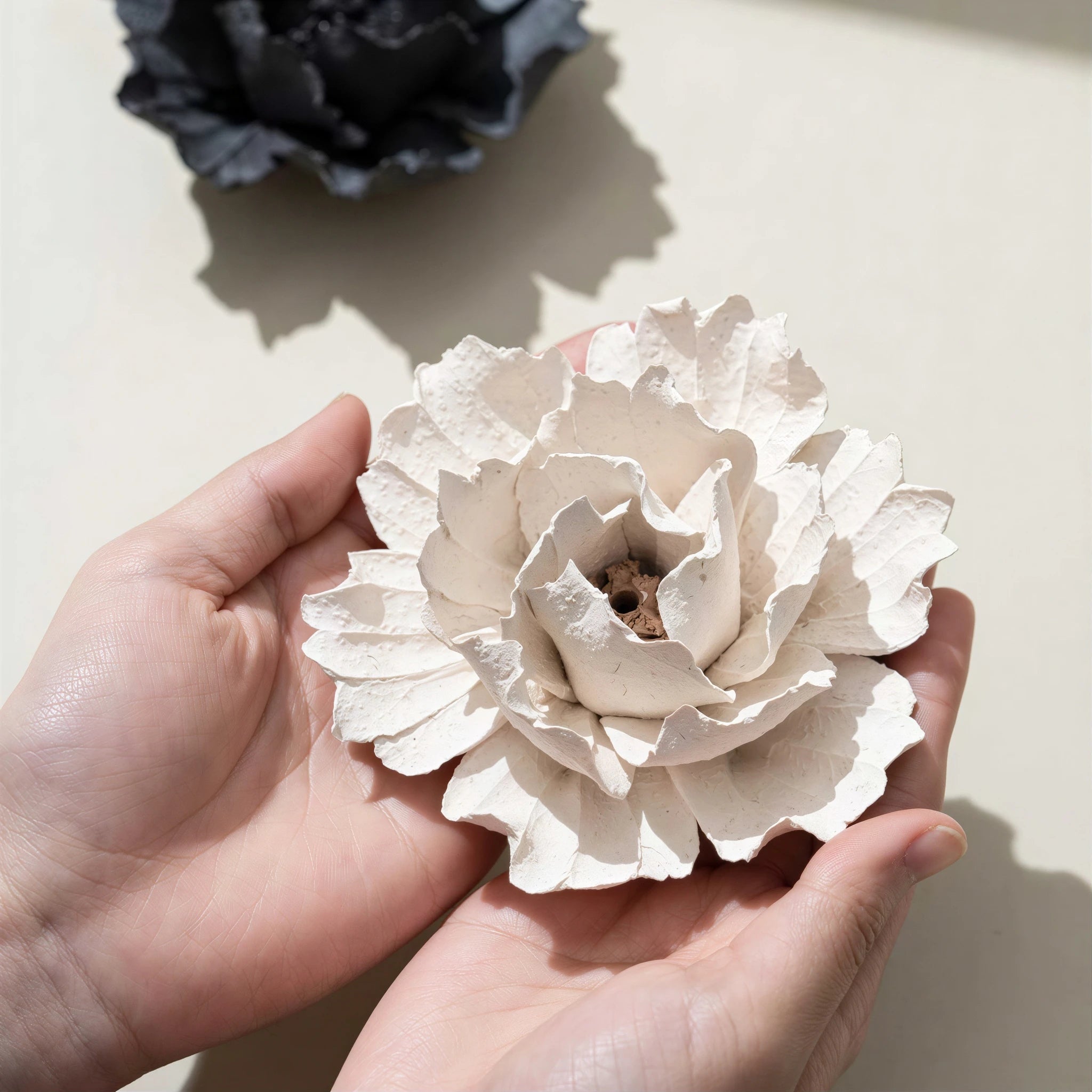Textured ceramic blossom held in two hands