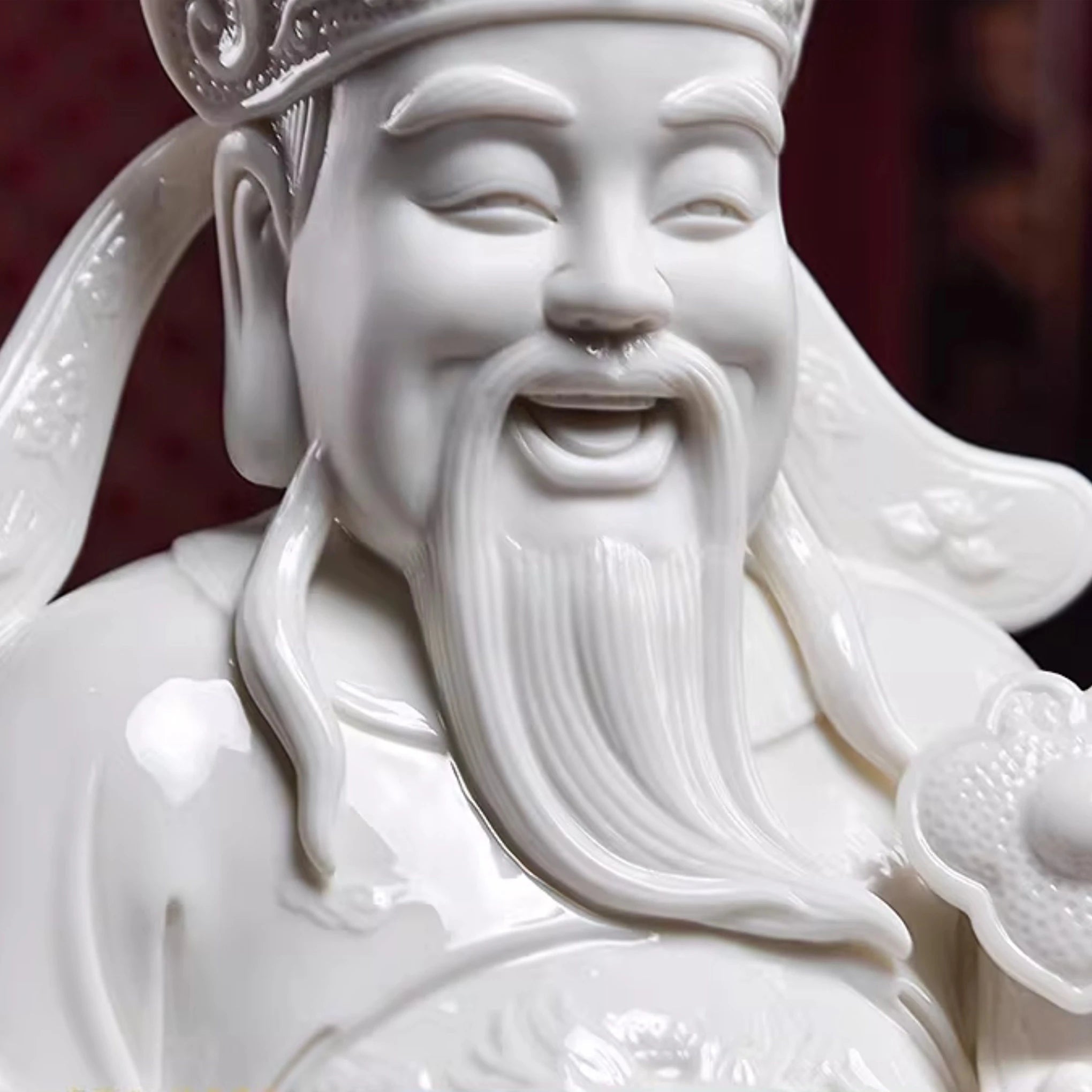 Close view of the face and white glaze on a Dehua Wen Caishen figure
