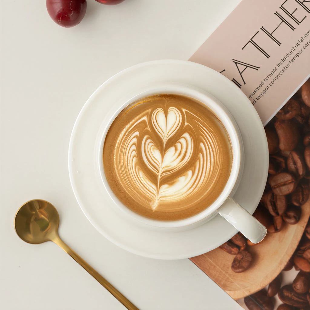 Top view of latte art in the white porcelain cup with saucer and spoon