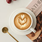 Top view of latte art in the white porcelain cup with saucer and spoon