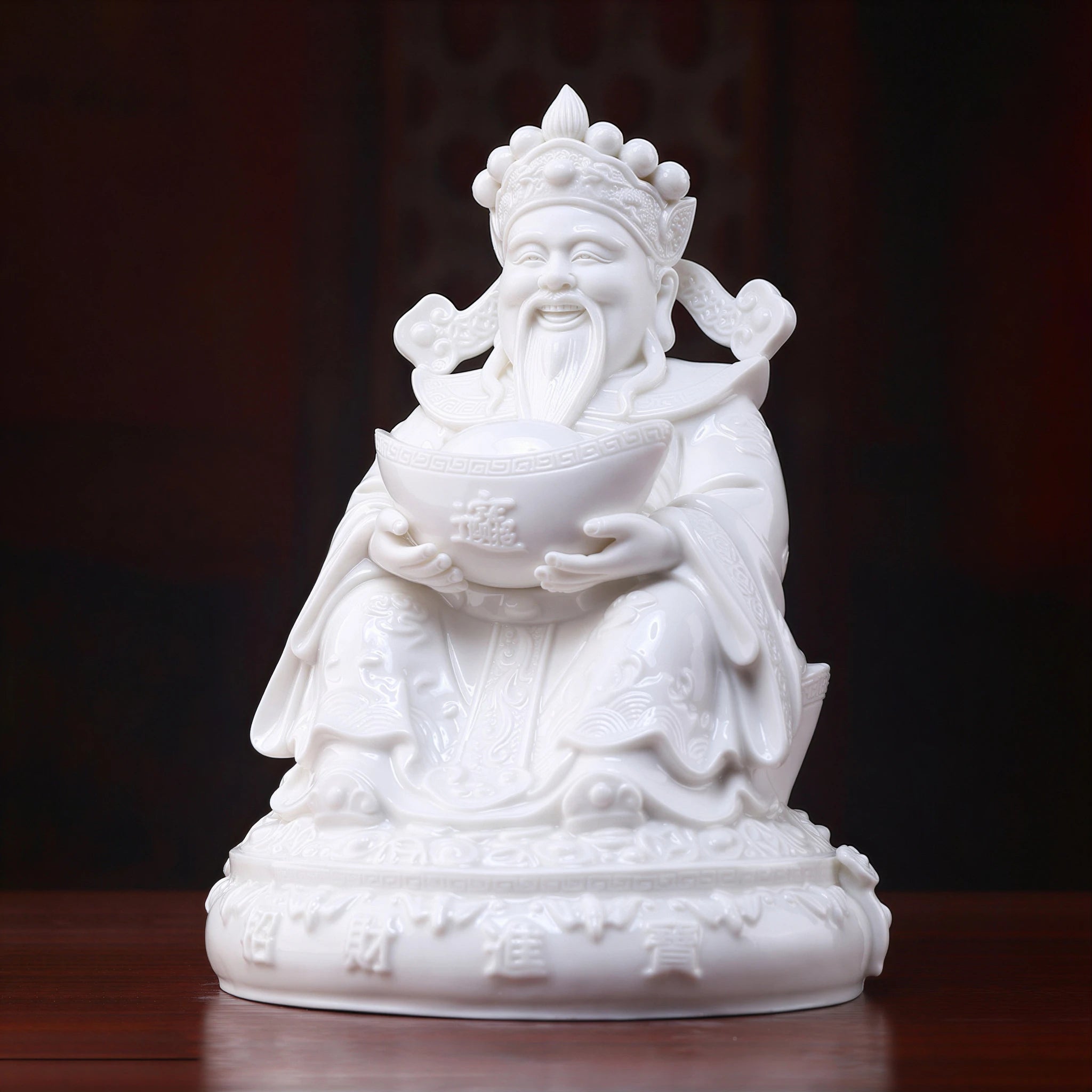 Angled view of the white Dehua Fu Bao Caishen and ingot