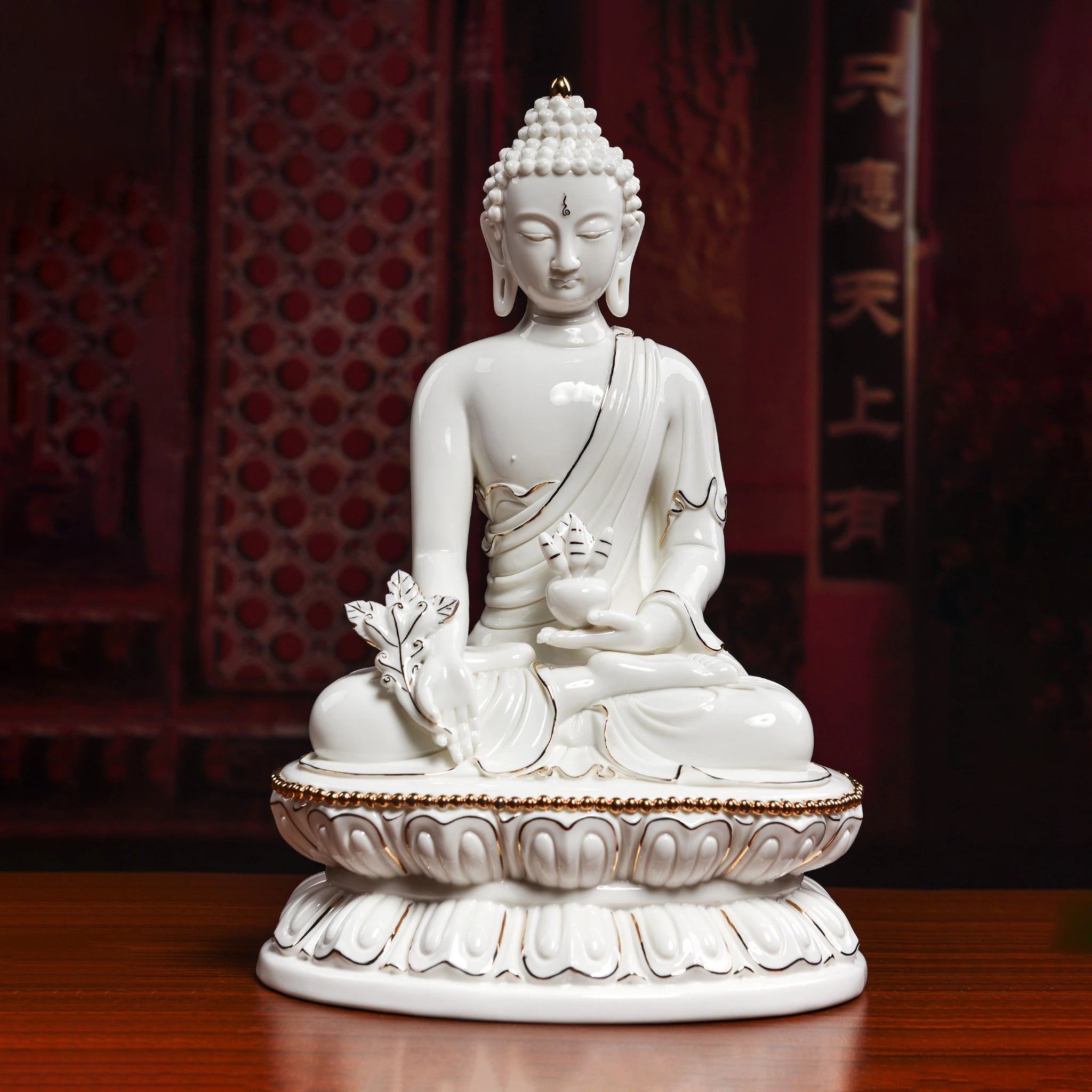 Front view of white Dehua porcelain Medicine Buddha with gold-toned details