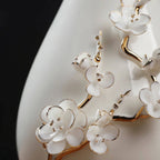 Close view of white plum petals and gold-toned relief details