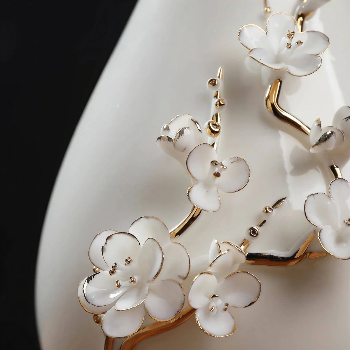 Close view of white plum petals and gold-toned relief details