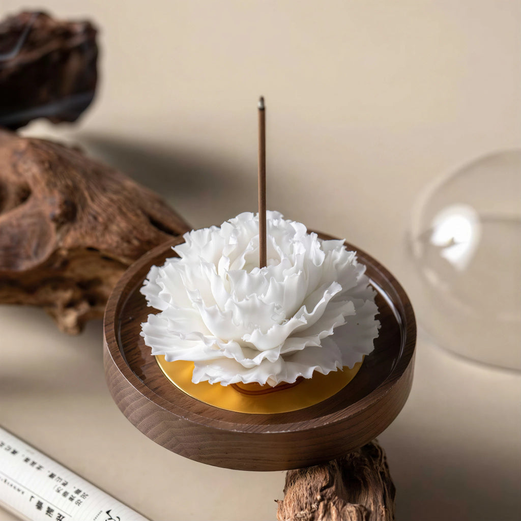 White Dehua porcelain carnation on a warm wood base