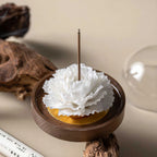 White Dehua porcelain carnation on a warm wood base