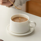 Coffee being stirred in the low Dehua white porcelain cup on its saucer
