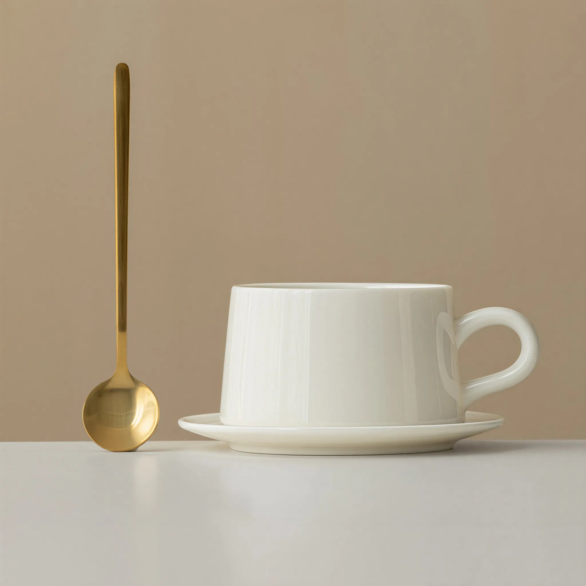 Dehua white porcelain coffee cup and saucer with a gold-colored alloy spoon