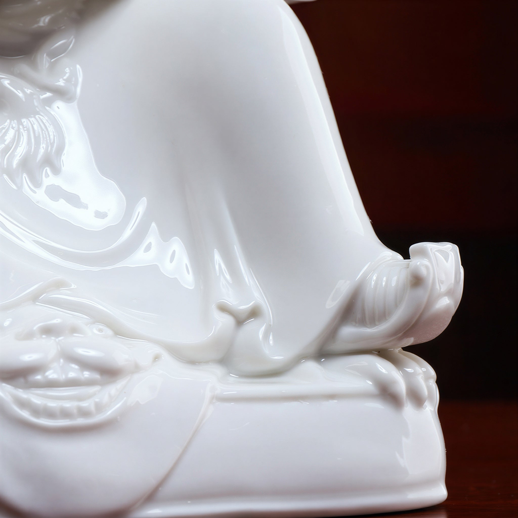 Detail of the white-glazed robe folds and armor relief