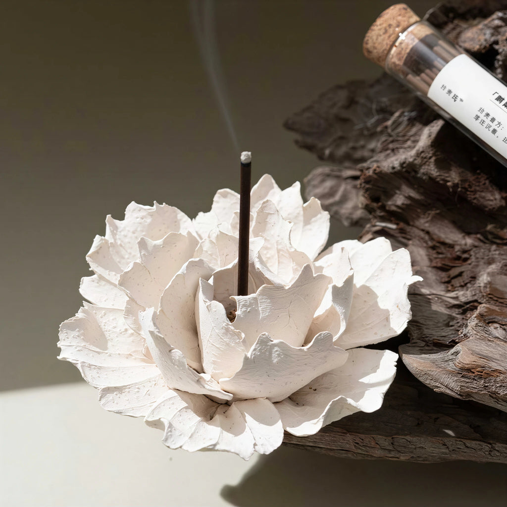 White textured ceramic blossom displayed on a dark wood tray
