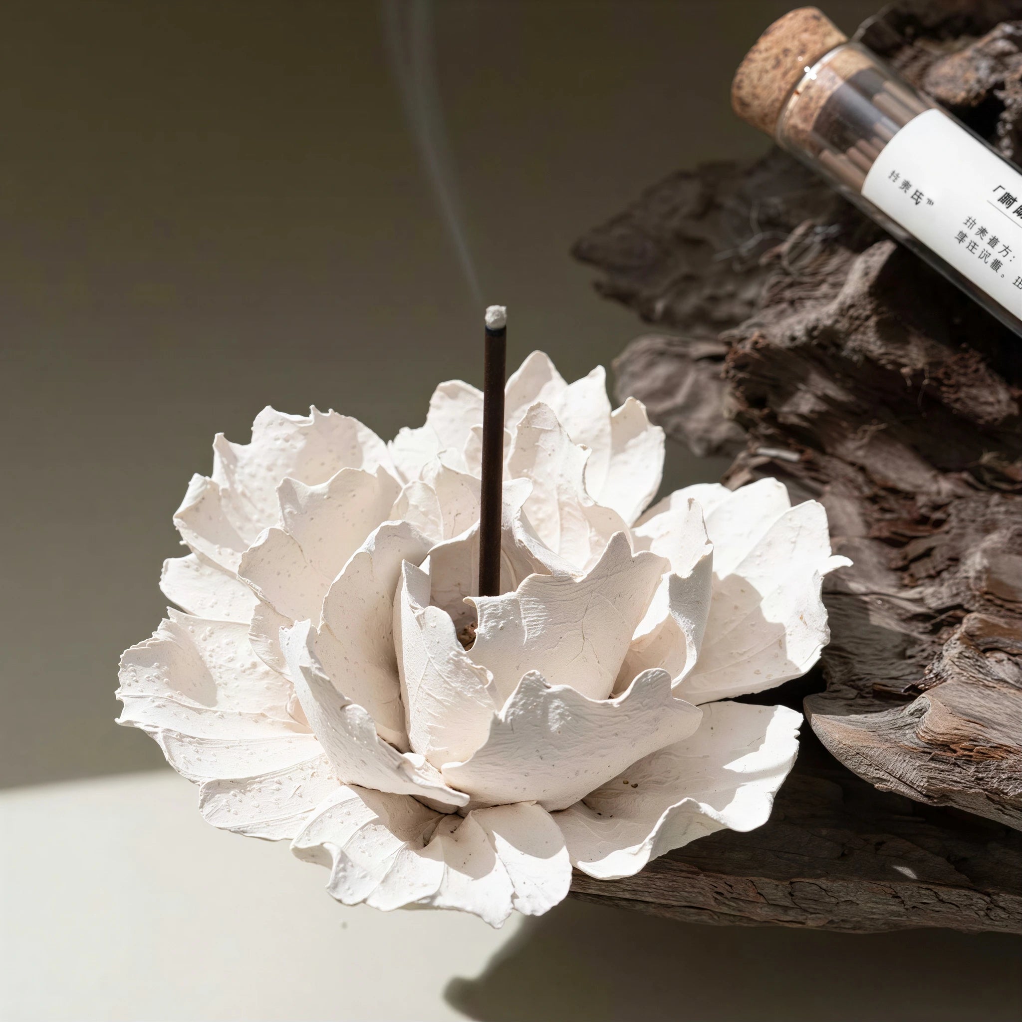White textured ceramic blossom displayed on a dark wood tray
