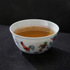 Doucai chicken cup filled with amber-colored tea