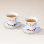 Two Dunhuang-inspired porcelain coffee cups with saucers