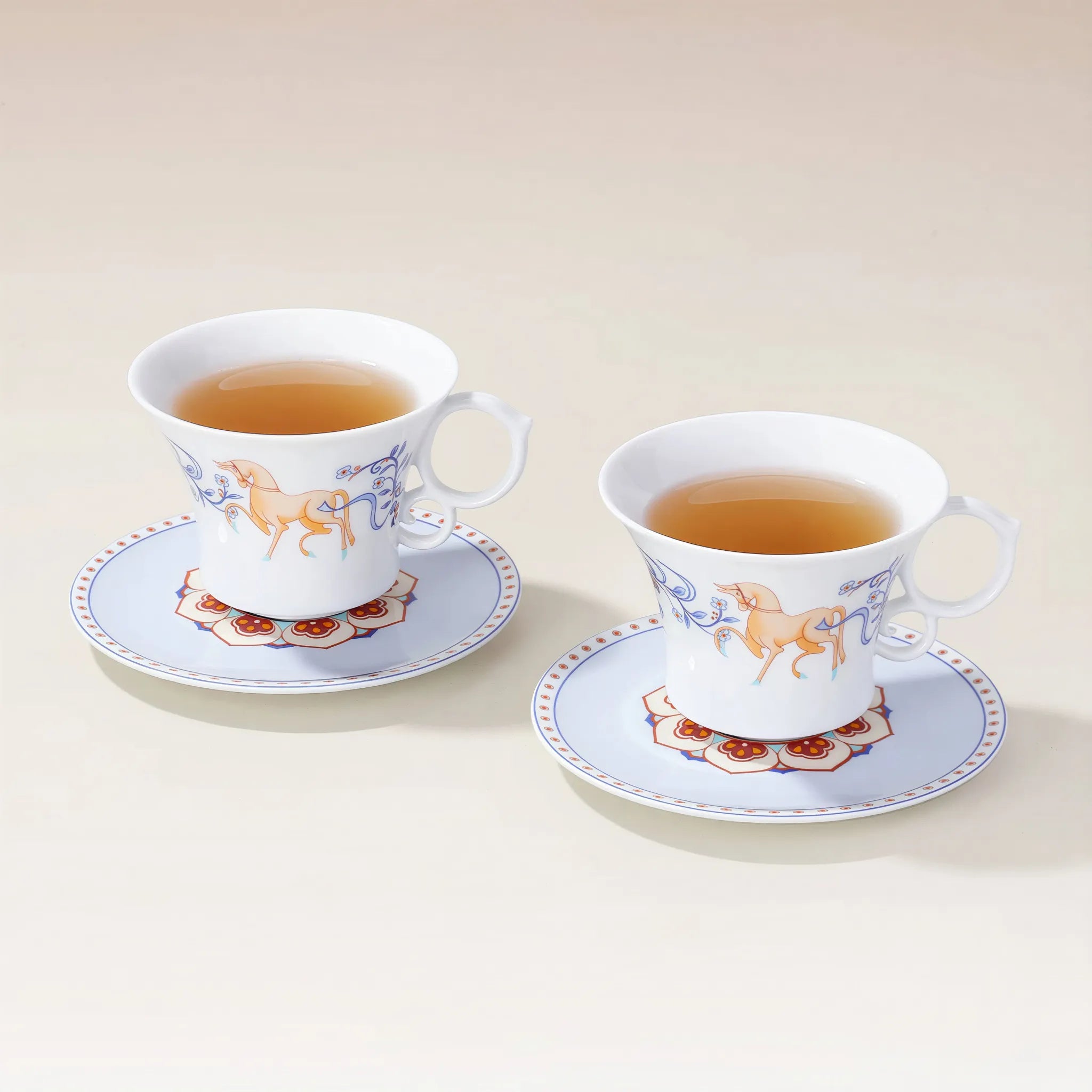 Two Dunhuang-inspired porcelain coffee cups with saucers