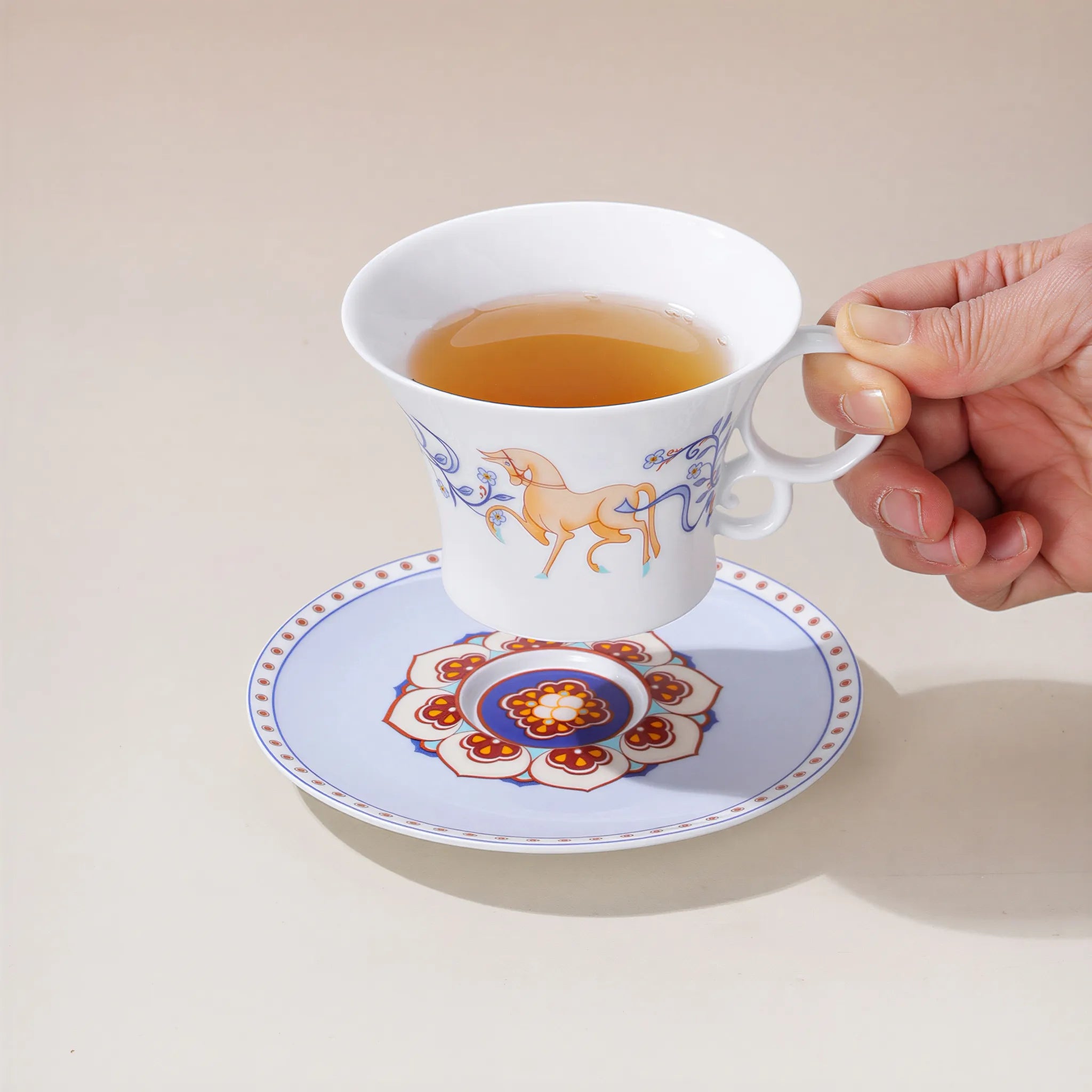 Dunhuang-inspired lapis blue porcelain coffee cup held in hand